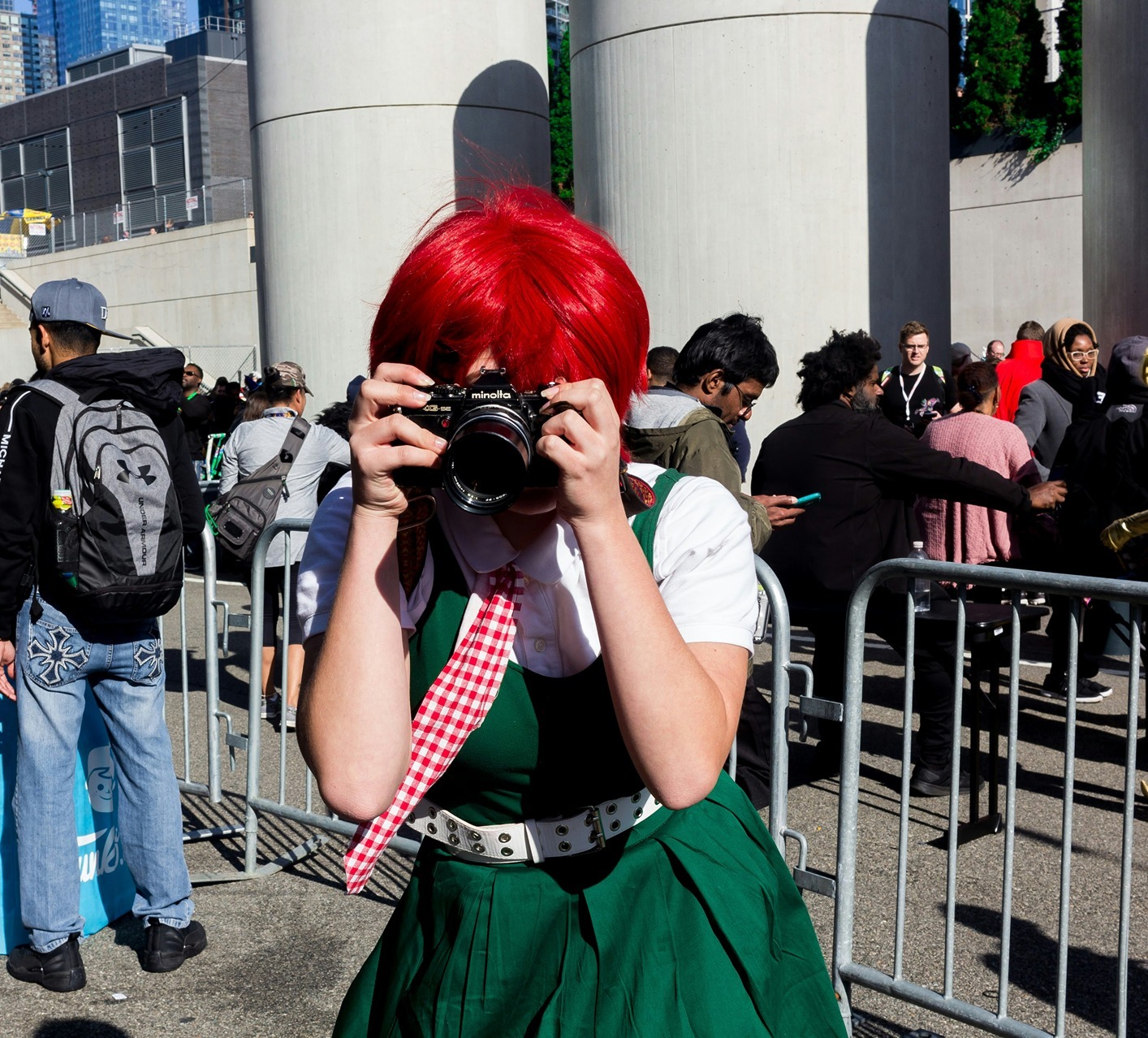 cosplayer with red hair, a green dress, and a camera