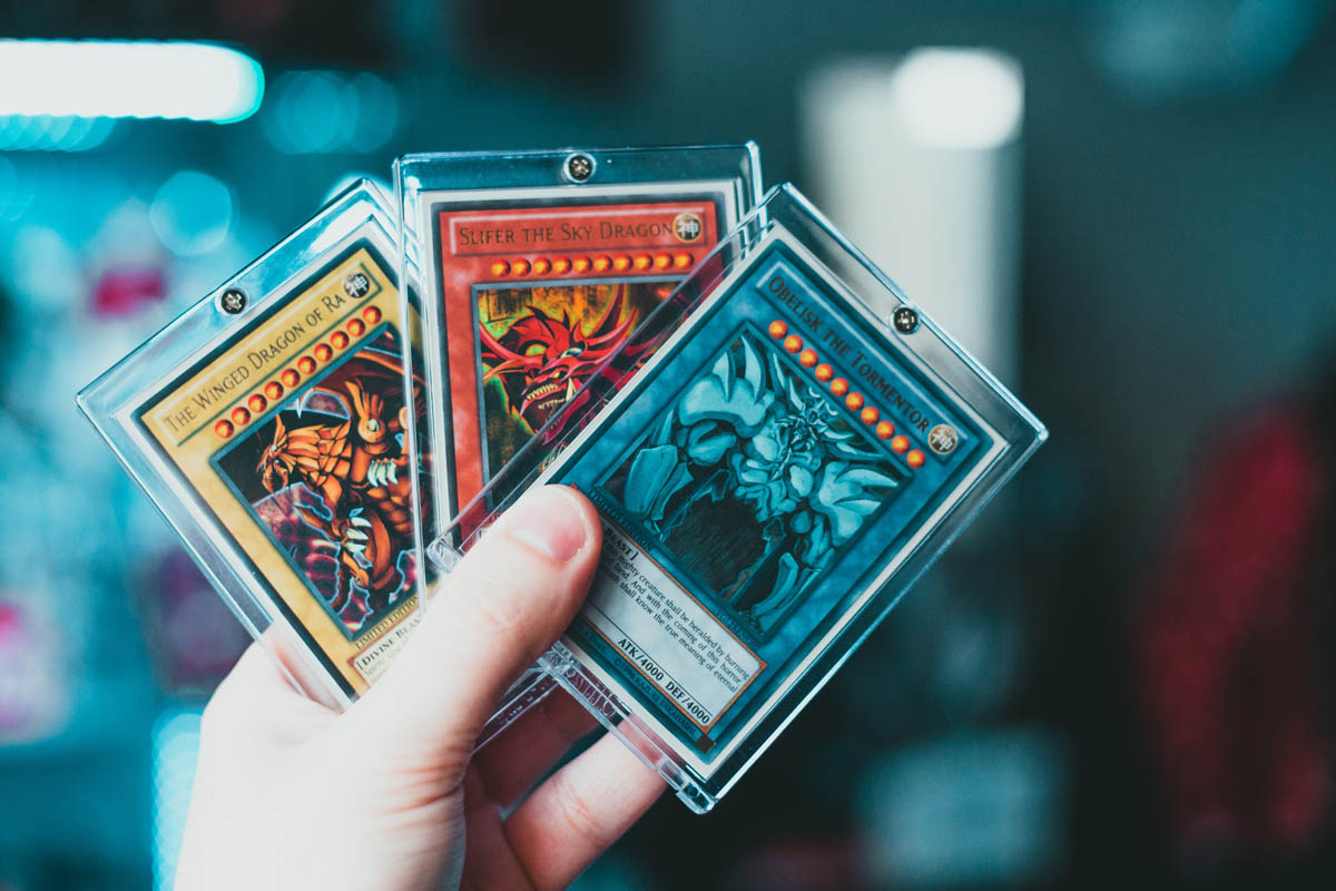 person holding three yugioh cards person holding three yugioh cards