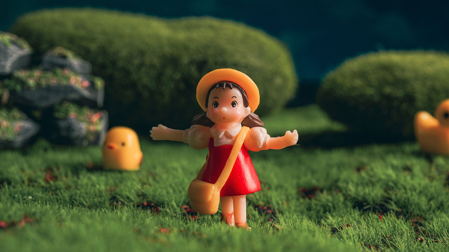 A Studio Ghibli Mei Kusakabe figurine on grass